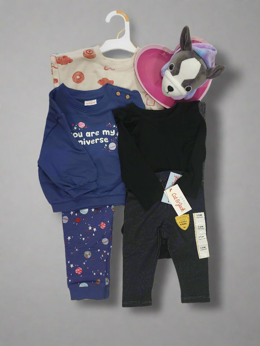 Baby clothing items including pants and a onesie on a table.